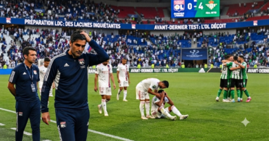 مدرب أولمبيك ليون بيتر بوش (على اليسار) ومساعده (على اليمين) يسيران على أرض الملعب بوجوه محبطة، بينما تظهر شاشة النتيجة في الخلفية مشيرة لخسارة فريقهما 0-4 أمام ريال بيتيس.