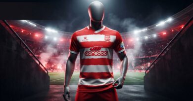 A professional, ultra-realistic photograph of a faceless grey mannequin standing in a dark, dramatic stadium tunnel, wearing the detailed red and white striped football jersey from image_64.png, complete with all logos (KElme, Club Africain crest, ooredoo, Boga) perfectly rendered and sharp.