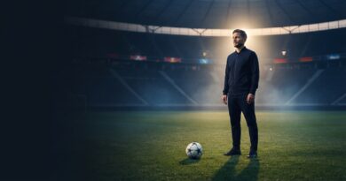 A cinematic sports editorial photograph of former German footballer Diego Demme standing thoughtfully on a pitch in an empty stadium at sunset, wearing an elegant dark navy training tracksuit with a football resting on the grass in front of him, set against a dark background with clean negative space on the left.